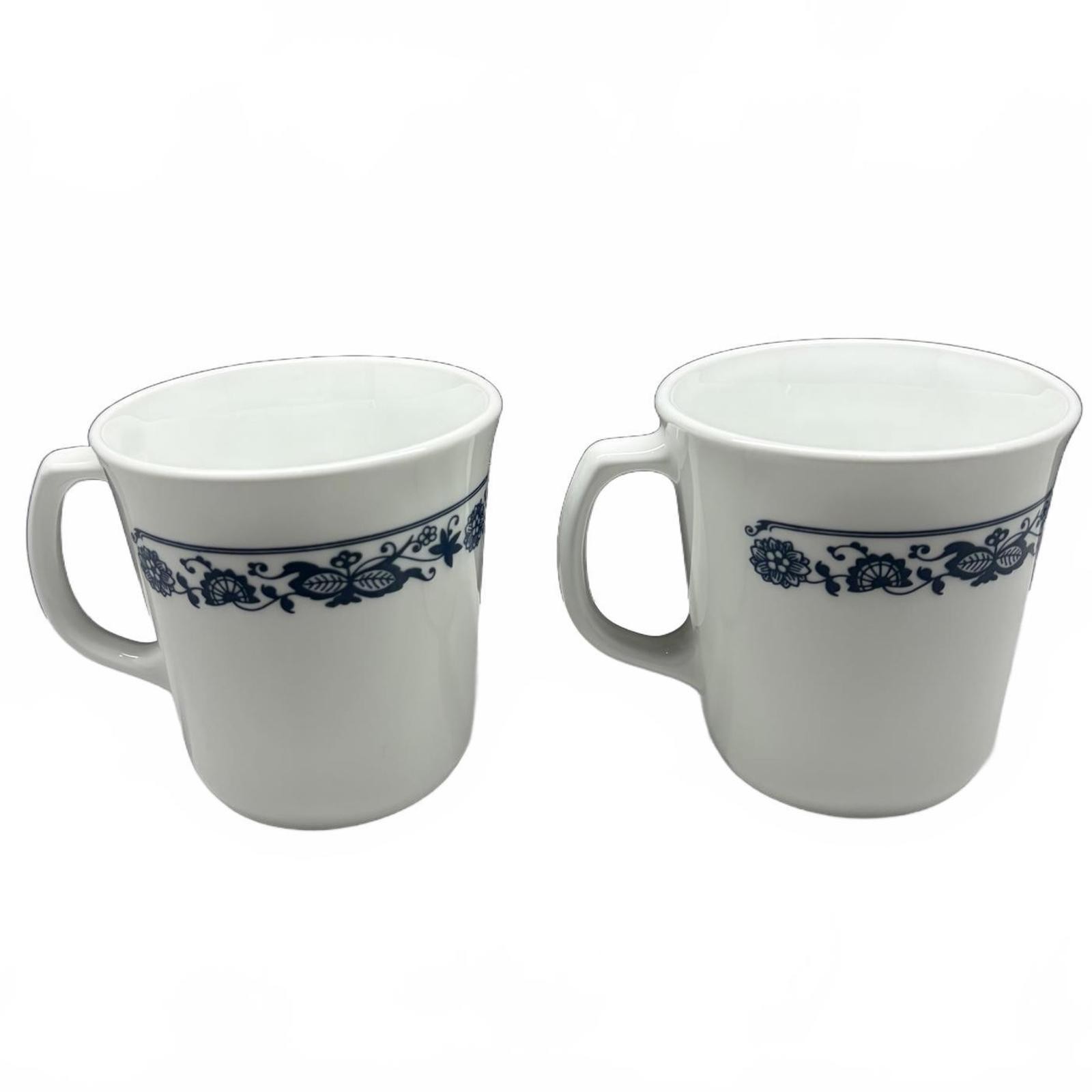 Two white Corning Ware Old Town Blue ceramic mugs with blue floral border.