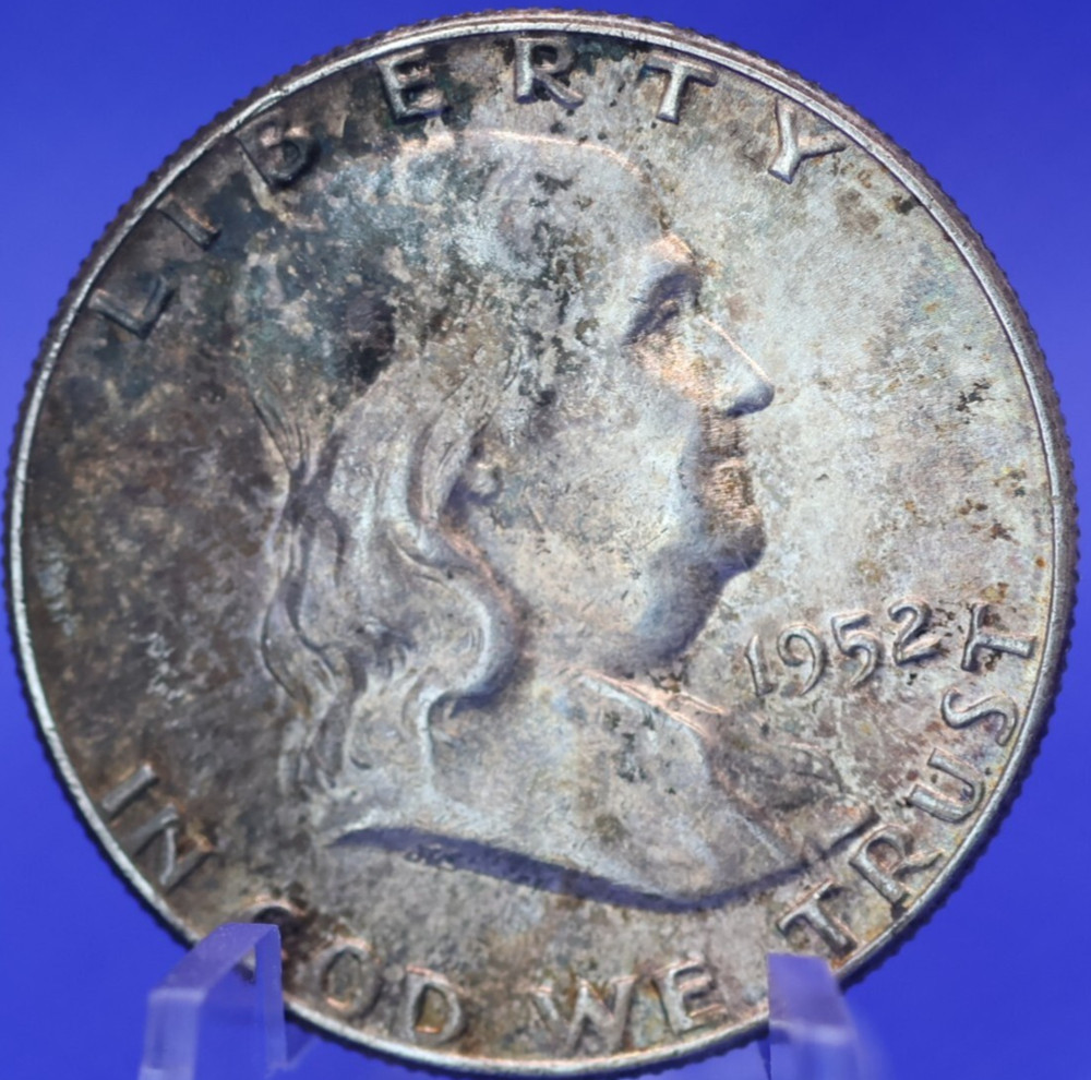 1952 About Uncirculated toned 90% silver Franklin half dollar.