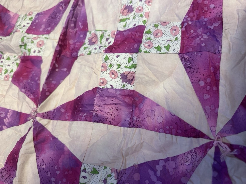 Handmade floral diamond pattern quilt with a multi-layered border.