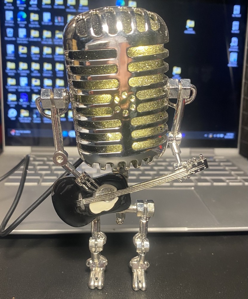 Microphone Robot holding a black guitar.