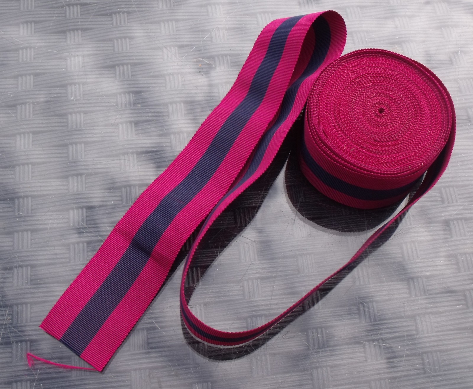 A 40 INCH LENGTH OF UNUSED OLD STOCK SILK DCM MEDAL RIBBON.