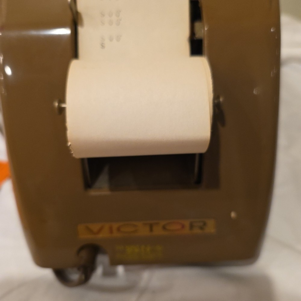 Vintage Victor Champion mechanical adding machine with a paper roll.