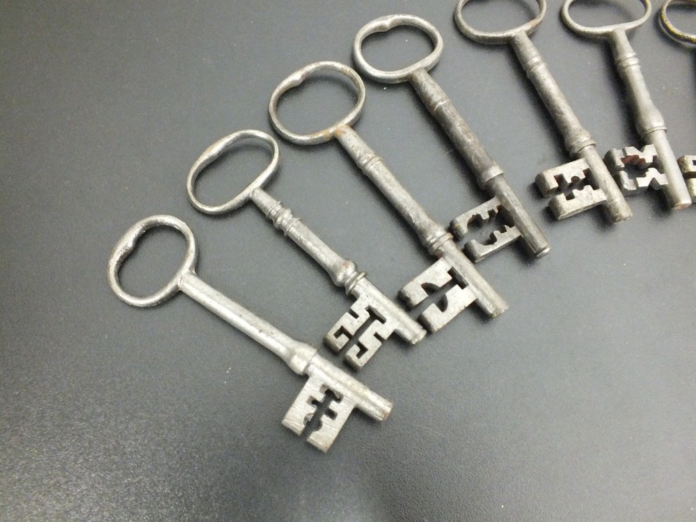 EIGHT ANTIQUE IRON WARDED KEYS .