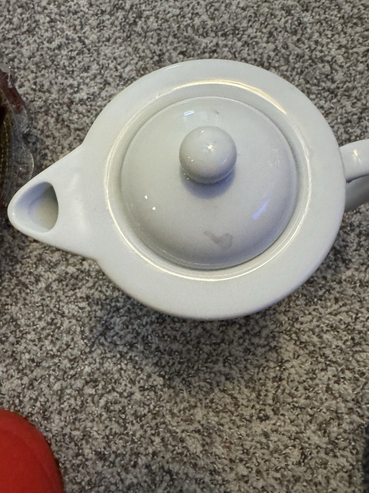 white ceramic teapot with a "Retired Pharmacist" design.