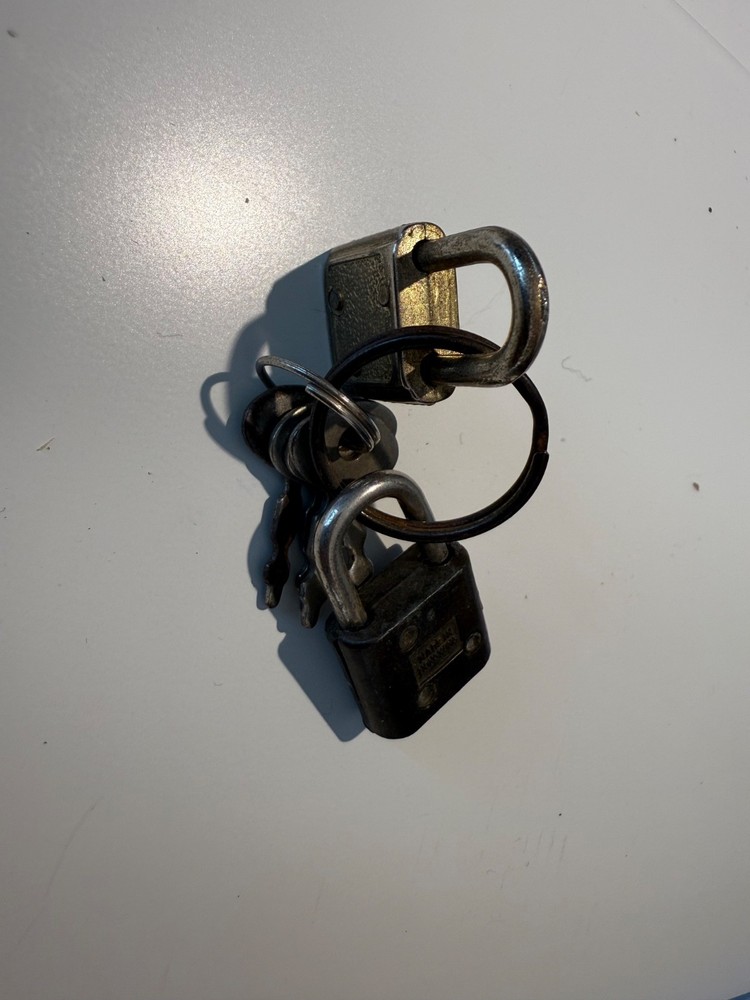 Two small luggage locks with four keys