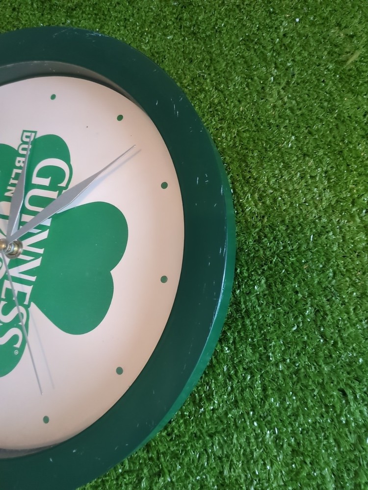 Guinness-branded wall clock with a shamrock design.