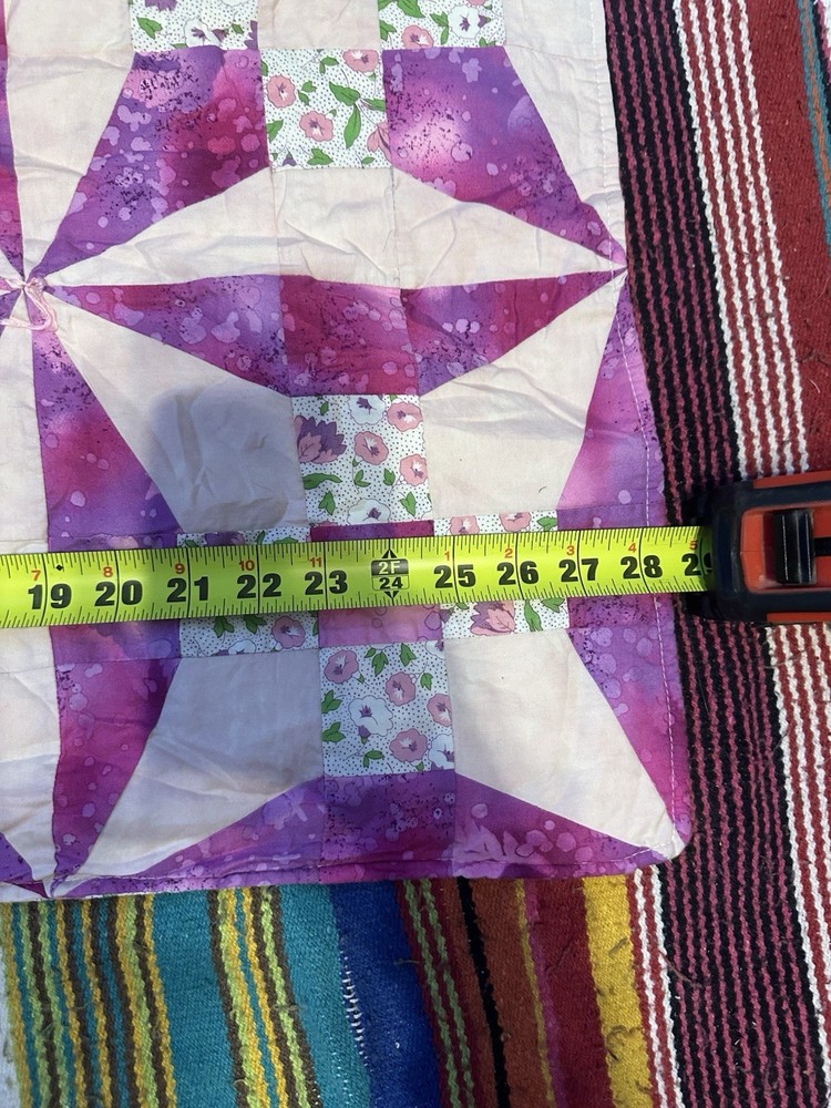 Handmade floral diamond pattern quilt with a multi-layered border.