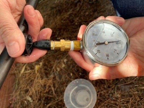 Drip irrigation pressure testing tool with 60 psi liquid filled gauge.