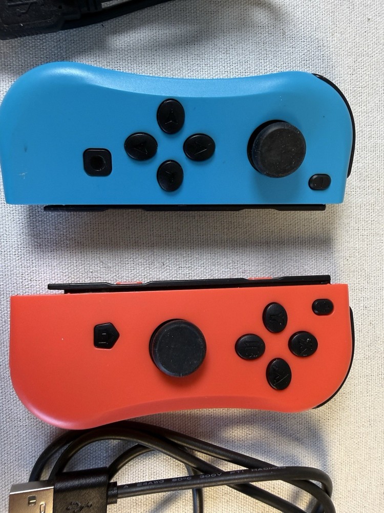 Nintendo Switch Joy-Con controllers accompanied by black USB-C charging cables.