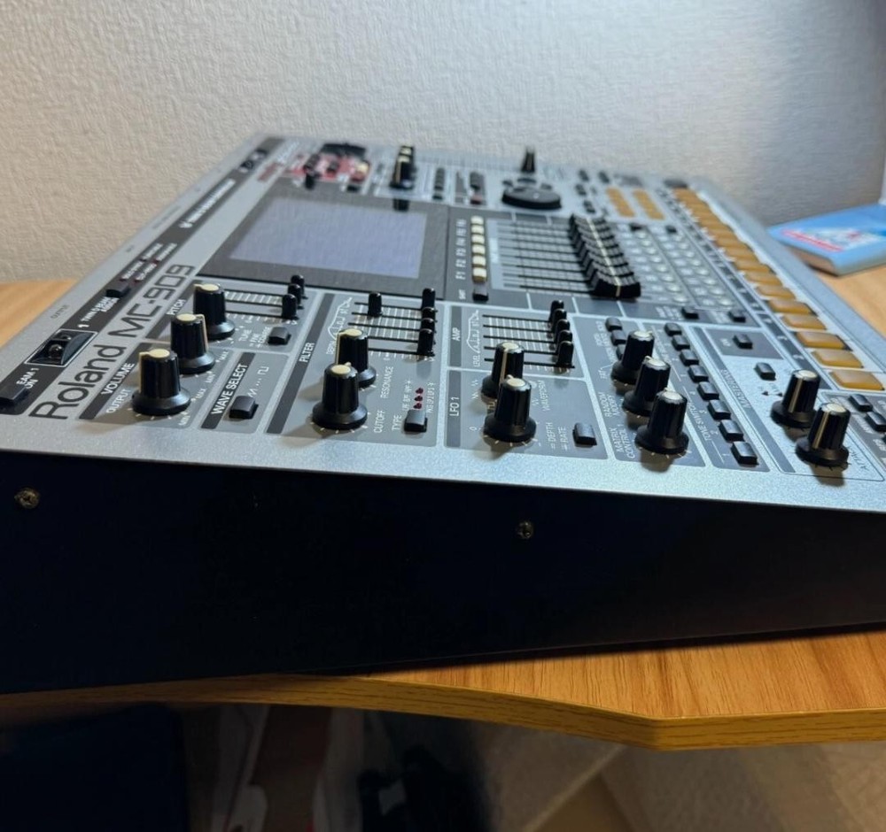 Roland MC-909 rhythm machine with adapter