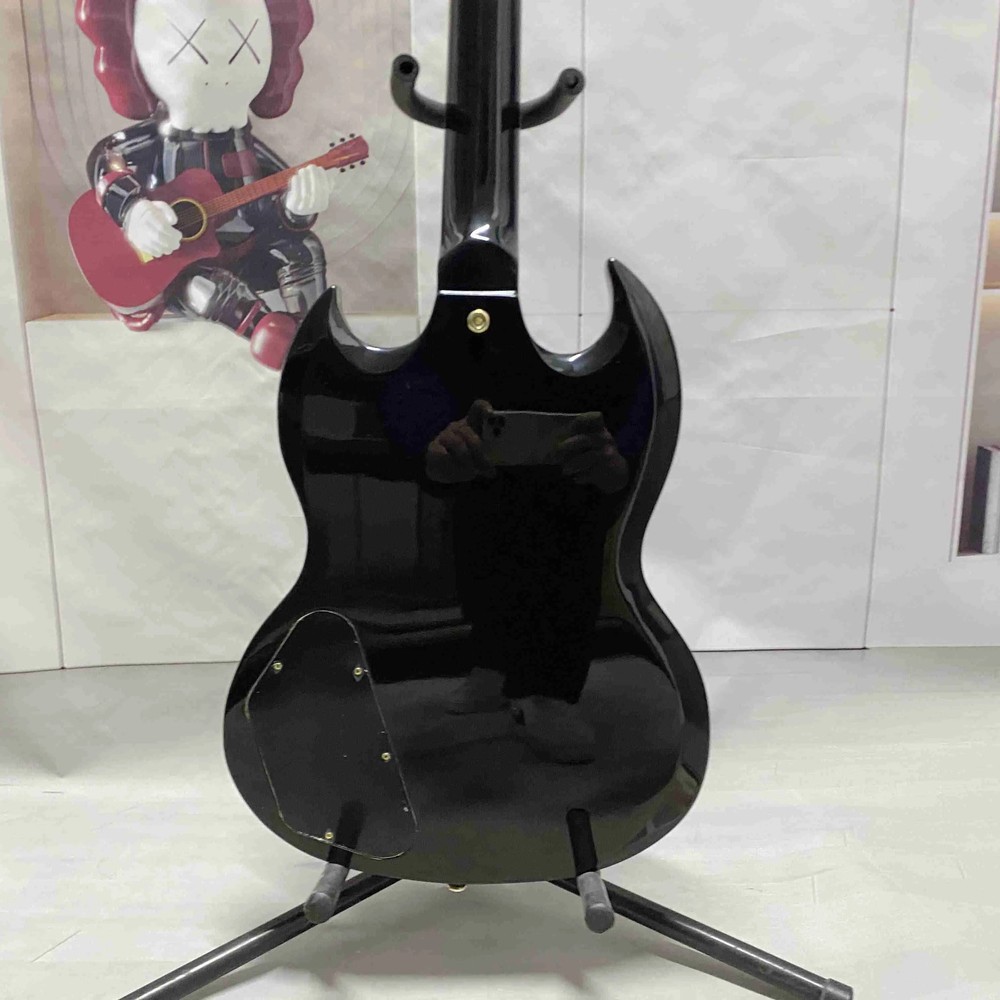 Black 6-string electric guitar with HH pickup, gold hardware, solid body