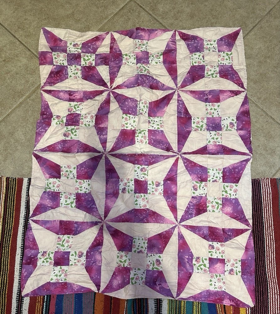 Handmade floral diamond pattern quilt with a multi-layered border.