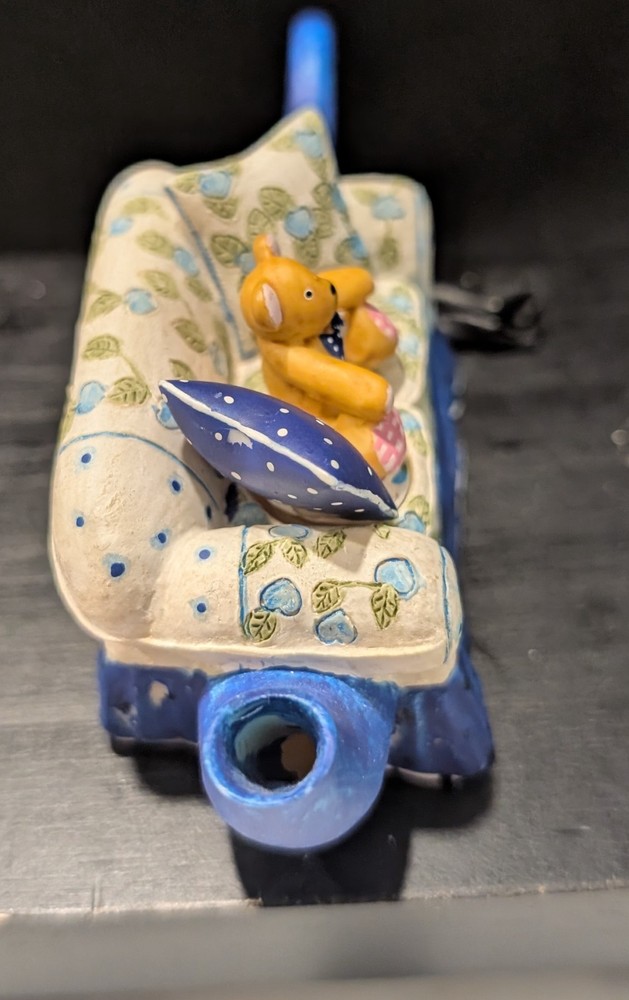 Miniature tea pot Teddy bear on couch.