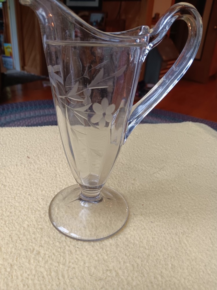 pressed clear glass pitcher featuring a flral design 7 inches