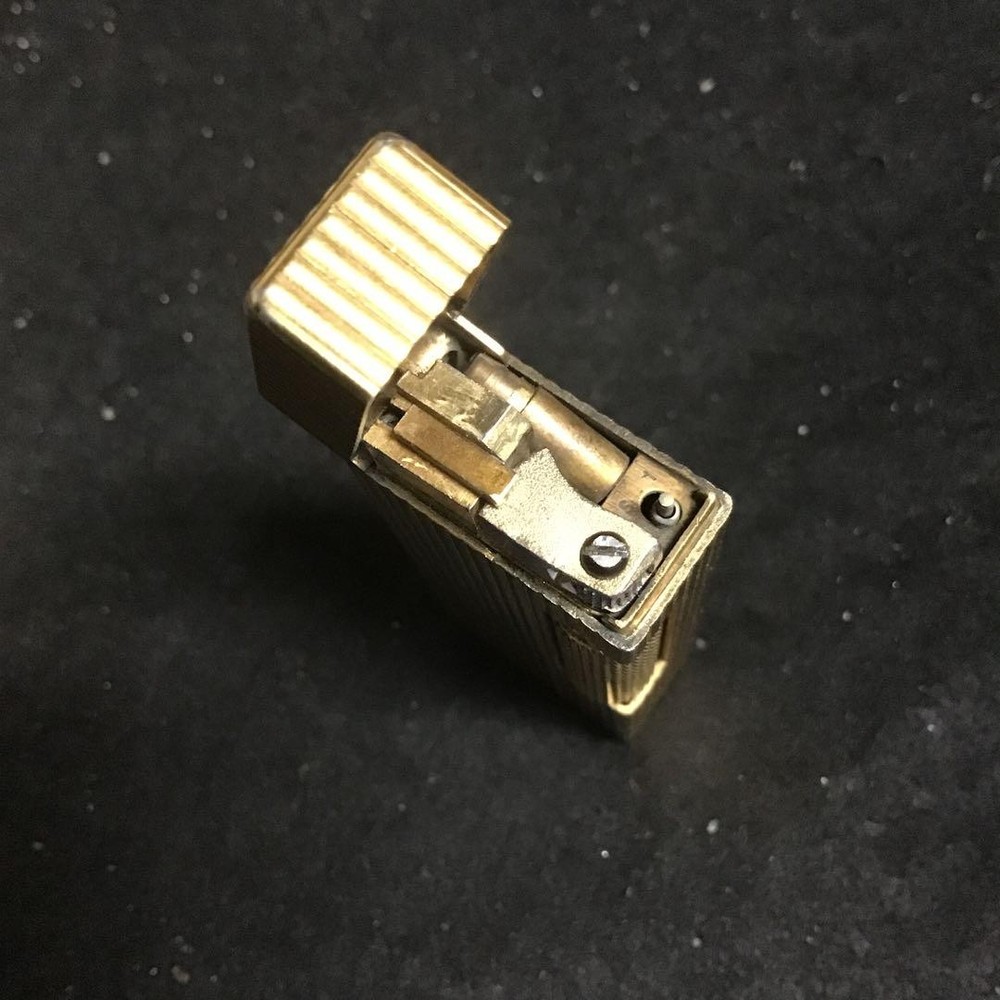 Overhauled gold dunhill lighter with striped pattern, ignition functioning well