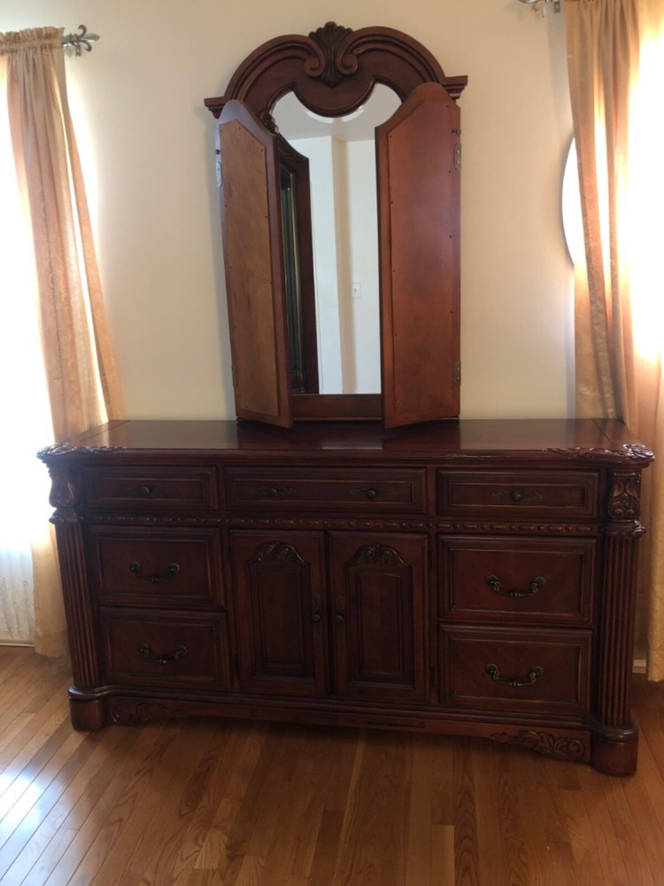 Brown dresser with adjustable three panel mirror.