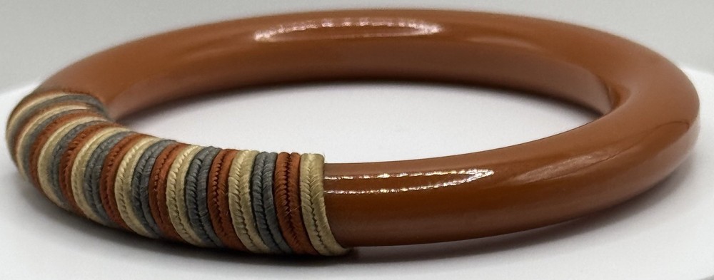 Red/white/blue string-wrapped, rust-colored Bakelite bracelet; tested