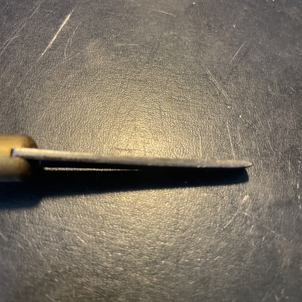 Wood handled screwdriver style tool with brass sparrow