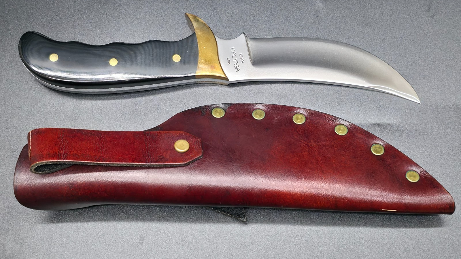 Buck Kalinga knife with black handle and brown leather sheath