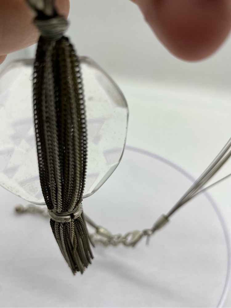Clear large glass stone with multi layered chain silver tassel