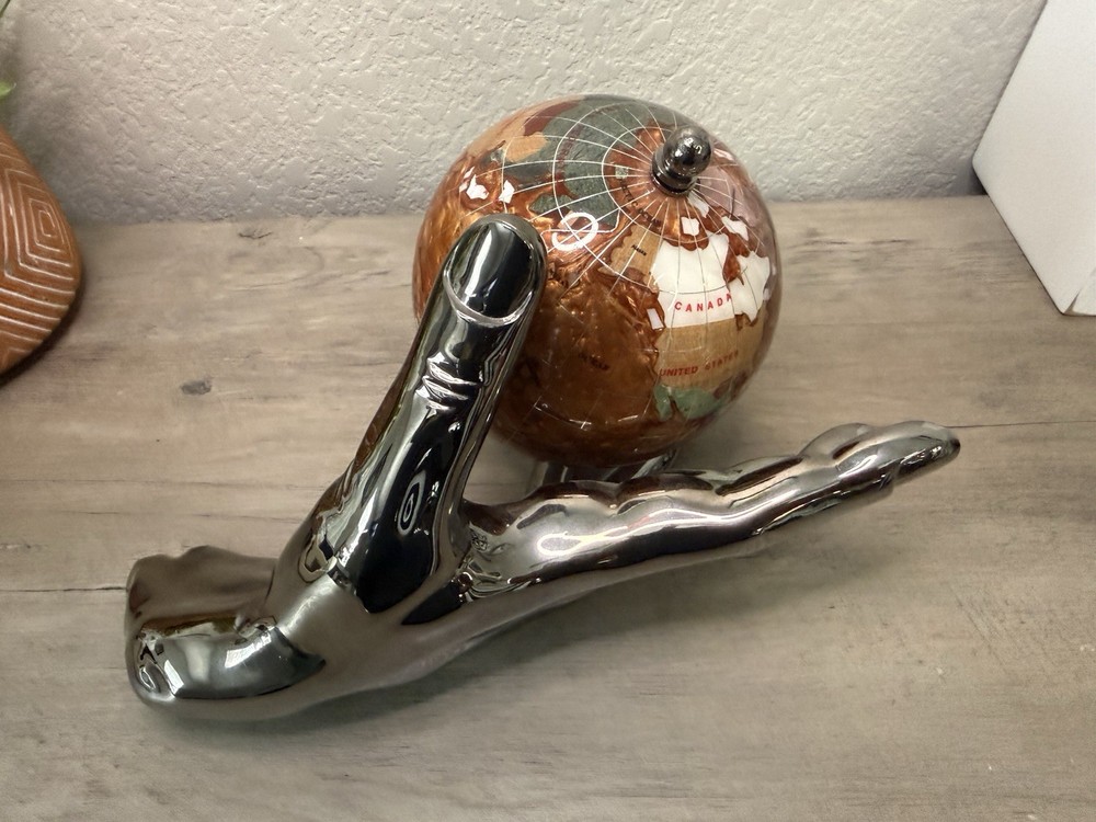 hand holding gemstone globe decor