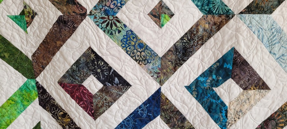 Hand made 55" X 62" Quilt In multiple batiks, purple batik back. Patchwork