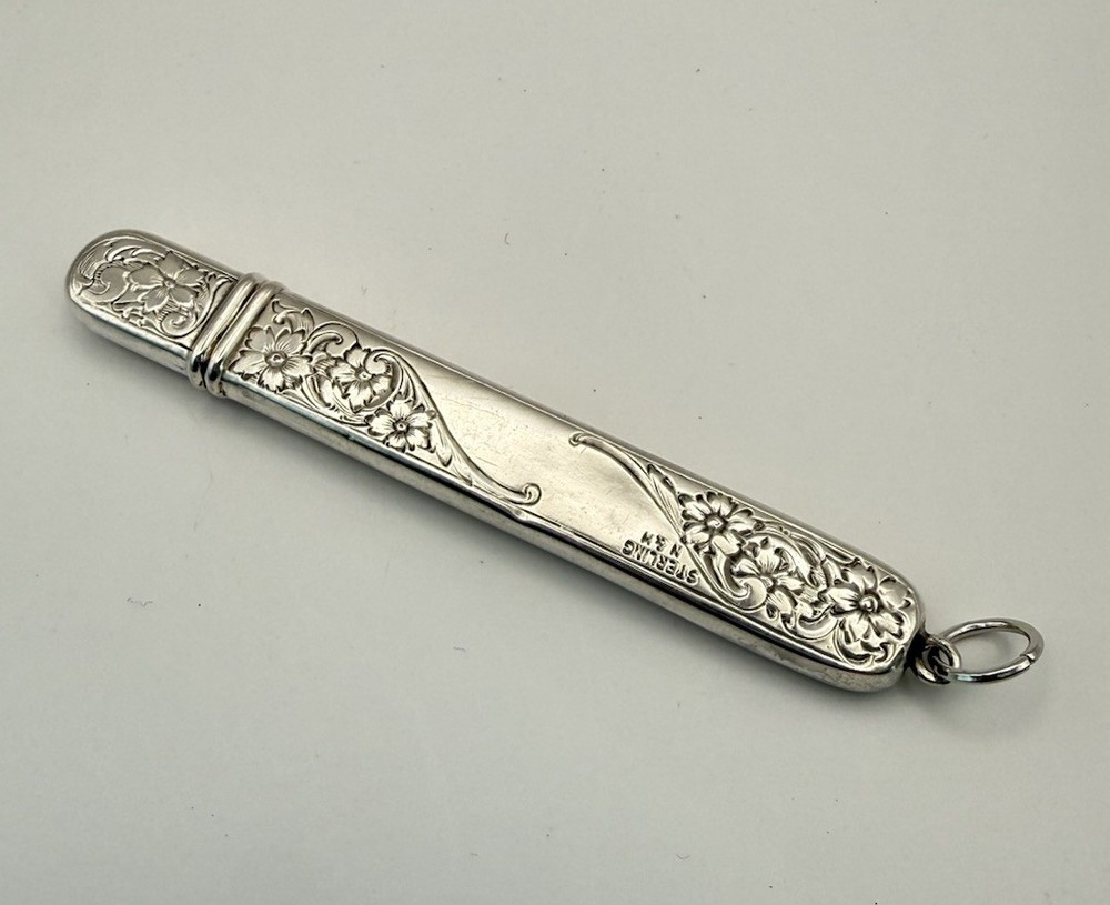This is an antique sterling silver chatelaine pencil holder