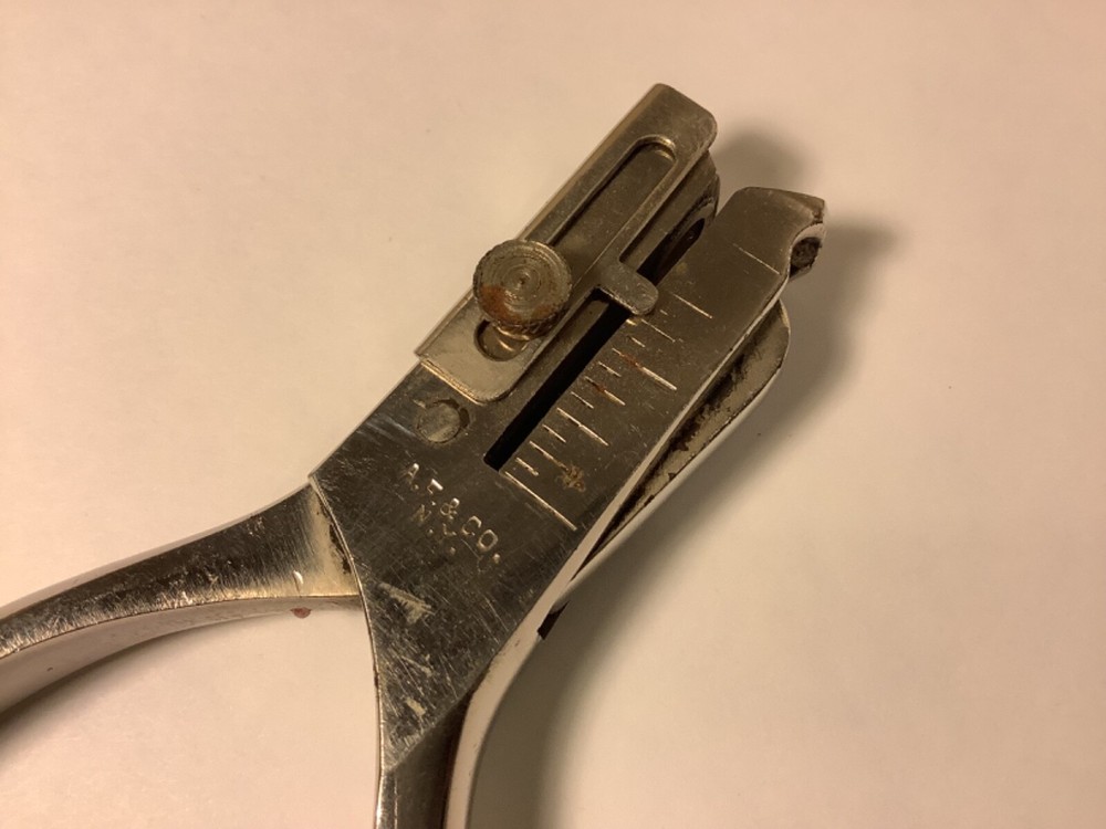 A.F. & Co. hole punch with spring handle action and adjustable punch depth guide