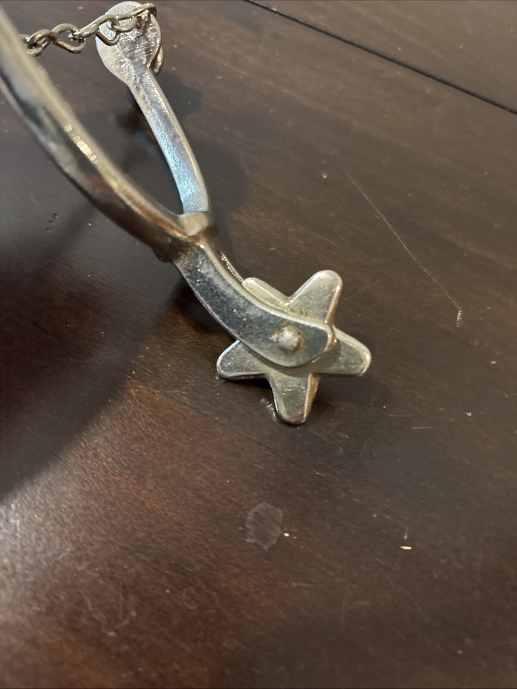 ONE UNMARKED SPUR - SILVER COLORED - SPINNING ROWEL