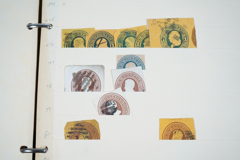 US COLLECTION OF 1,200+ STATIONERY CUT SQUARE STAMPS STORED IN STOCKBOOK