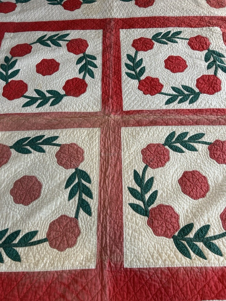 Handmade appliqué quilt with red rose pattern