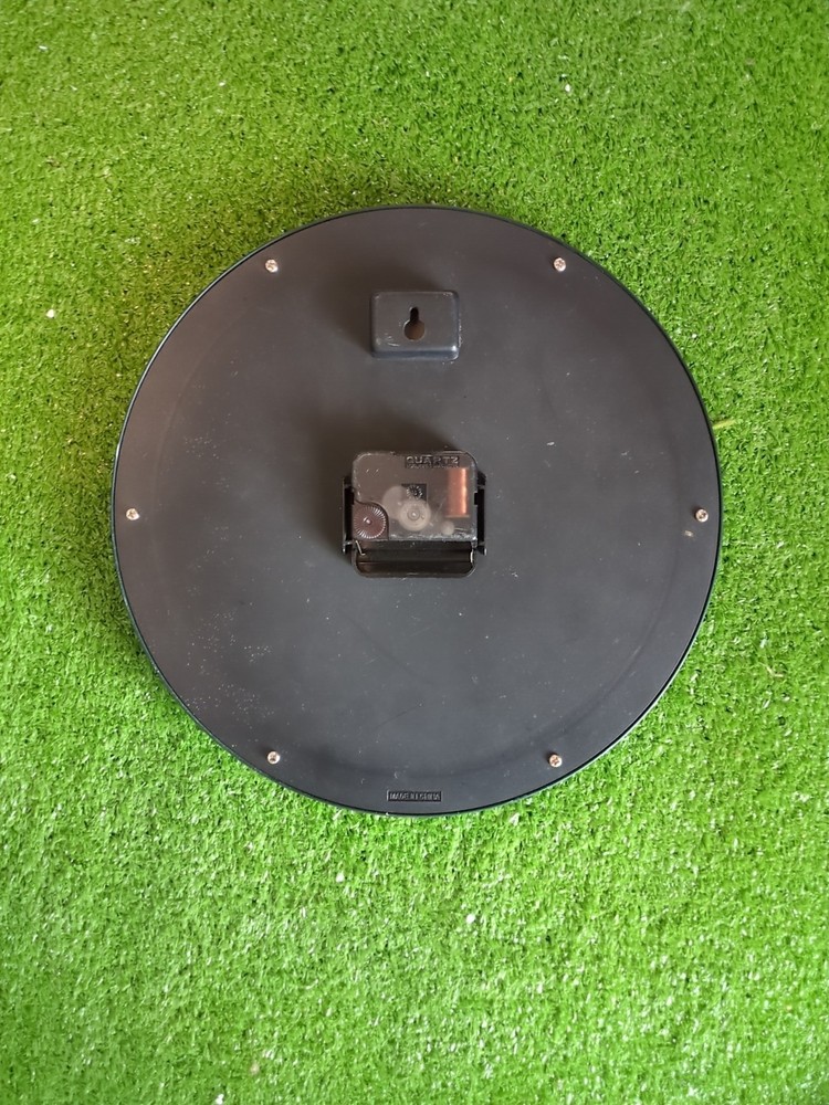 Guinness-branded wall clock with a shamrock design.