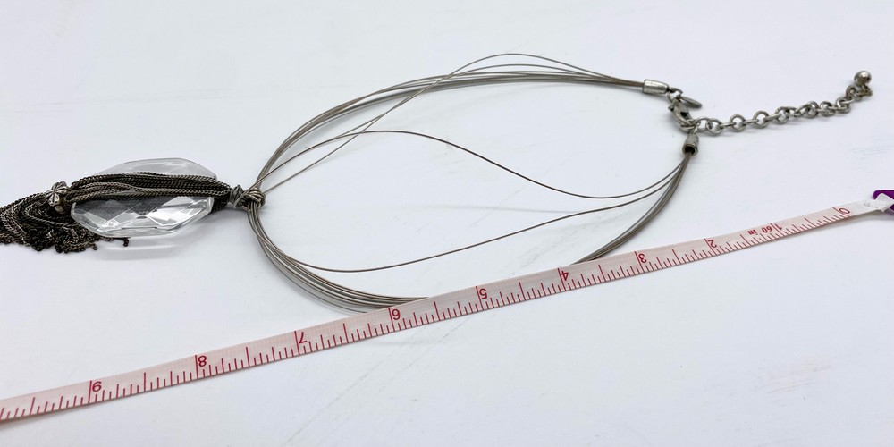 Clear large glass stone with multi layered chain silver tassel