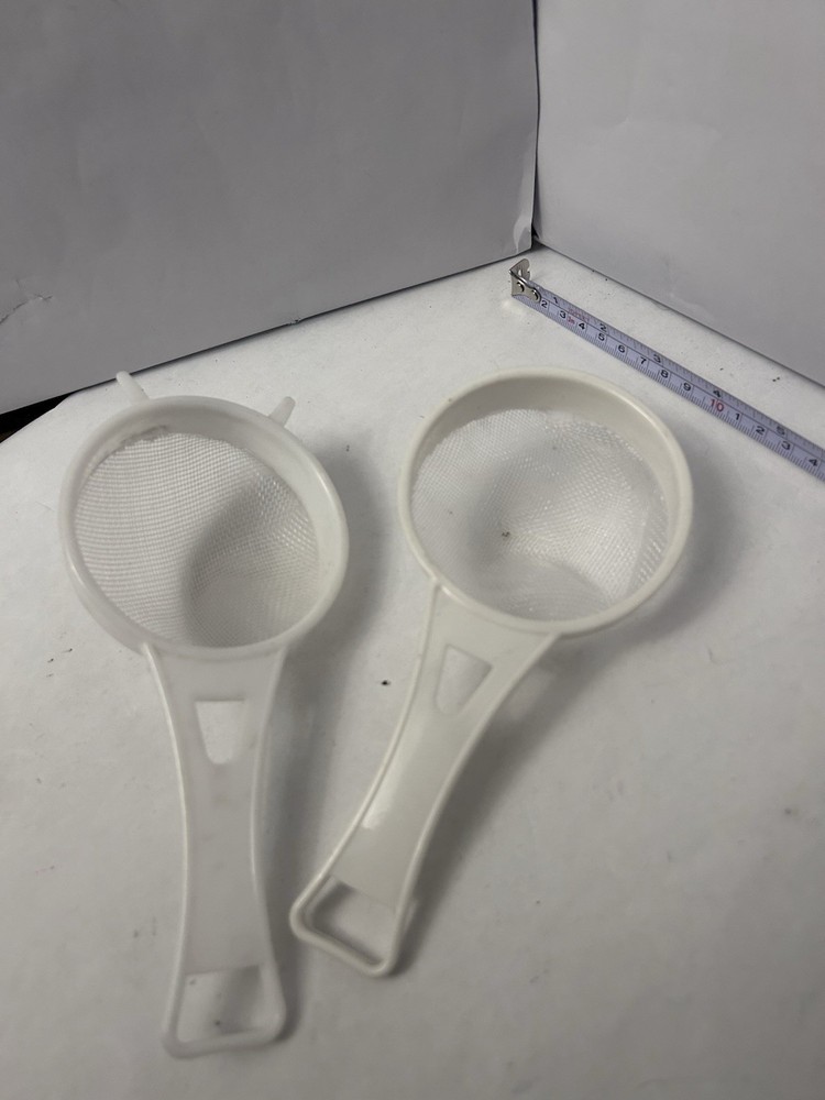 2 White handheld plastic handle sifters