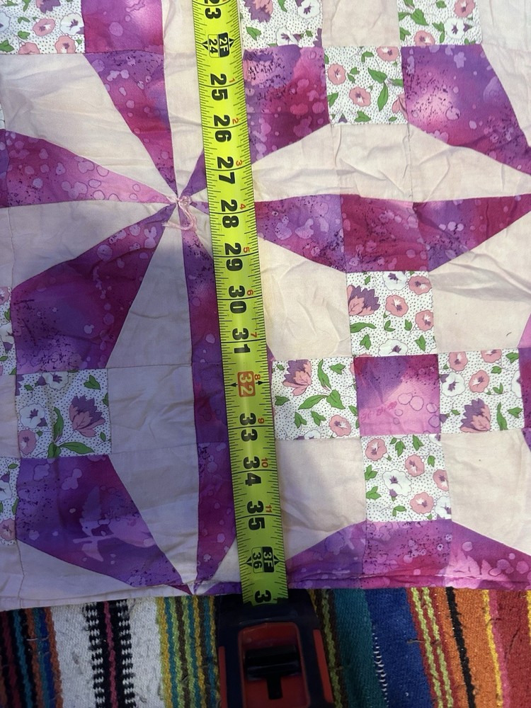 Handmade floral diamond pattern quilt with a multi-layered border.