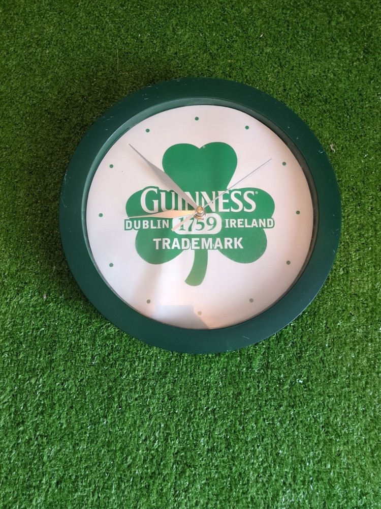 Guinness-branded wall clock with a shamrock design.