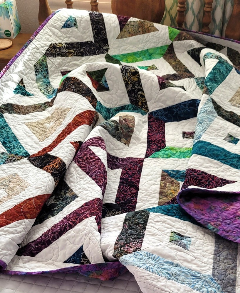 Hand made  55" X 62" Quilt In multiple batiks, purple batik back.  Patchwork