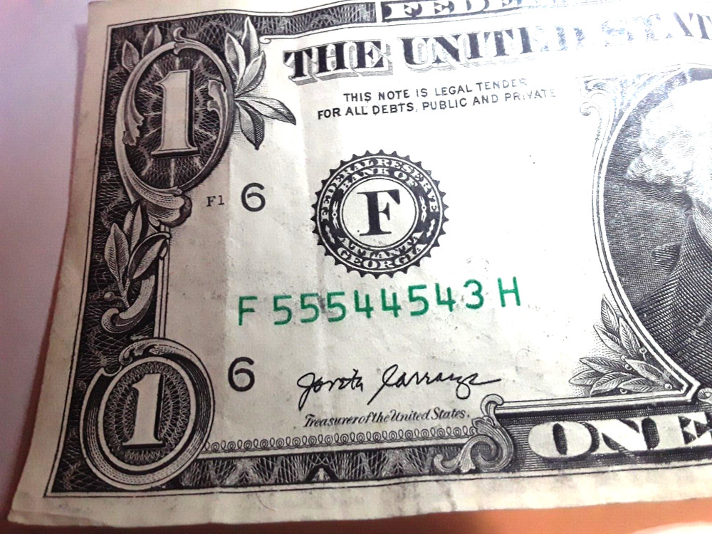 one dollar serial number print error. Ink between numbers