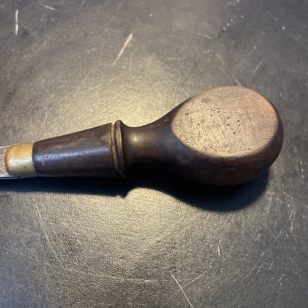 Wood handled screwdriver style tool with brass sparrow