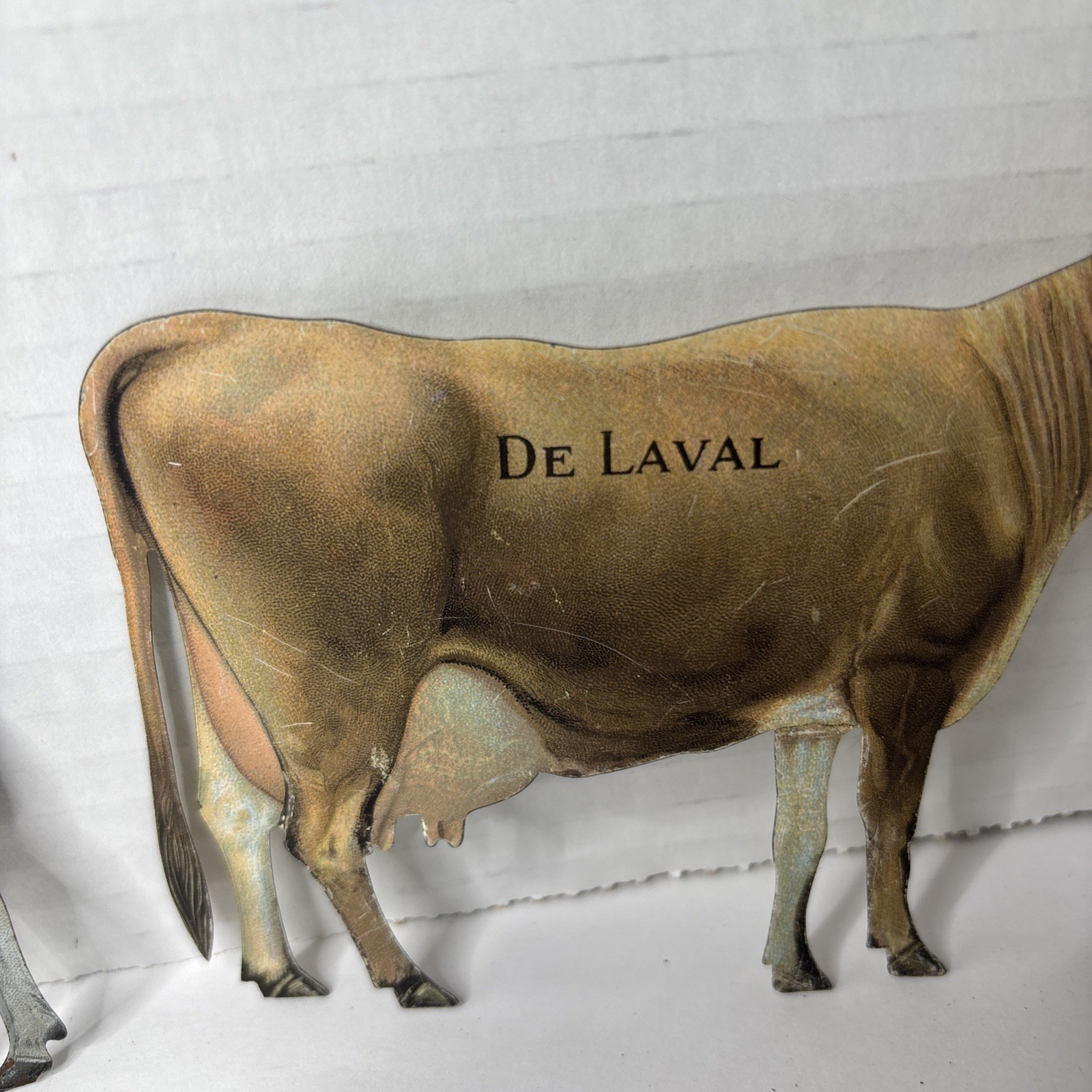 Pair of Antique DeLaval tin die cut cow and calf advertising cream separator ads