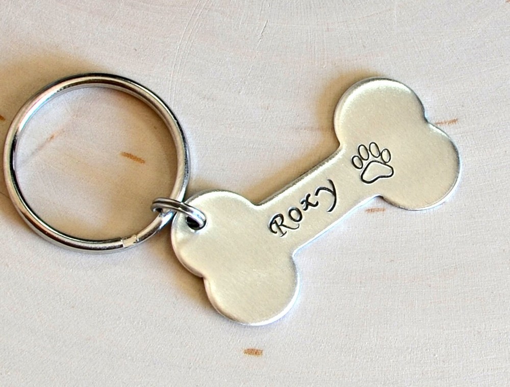 Silver bone shaped dog tag with name and phone number made from solid sterling
