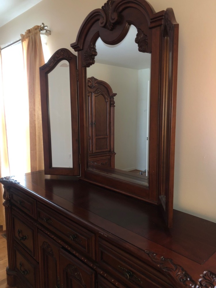 Brown dresser with adjustable three panel mirror.