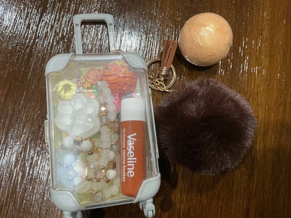 cute mini yellow suitcase with various trinkets inside