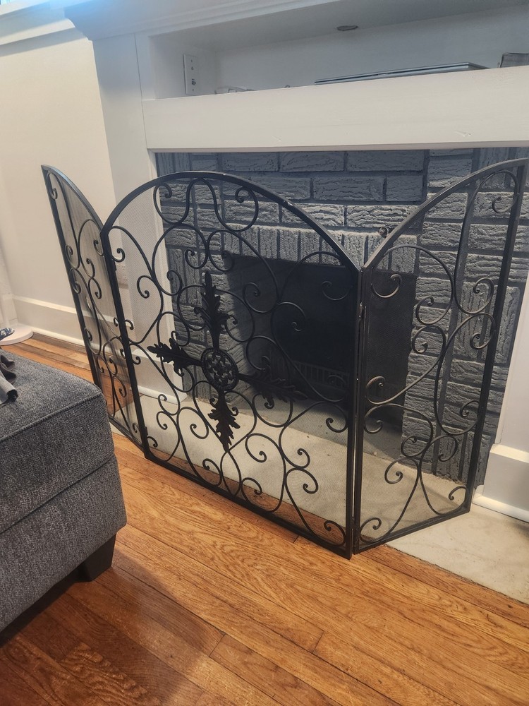 wrought iron, three-panel fireplace screen with ornate scrollwork and a mesh