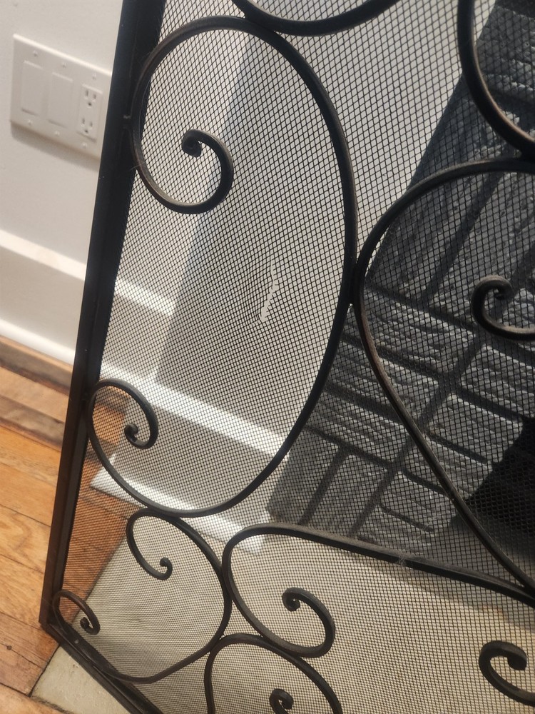 wrought iron, three-panel fireplace screen with ornate scrollwork and a mesh
