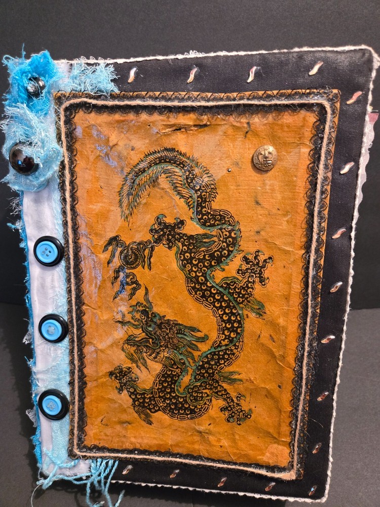 Junk journal with dragon front and back with lights inside. Pockets/tags too.