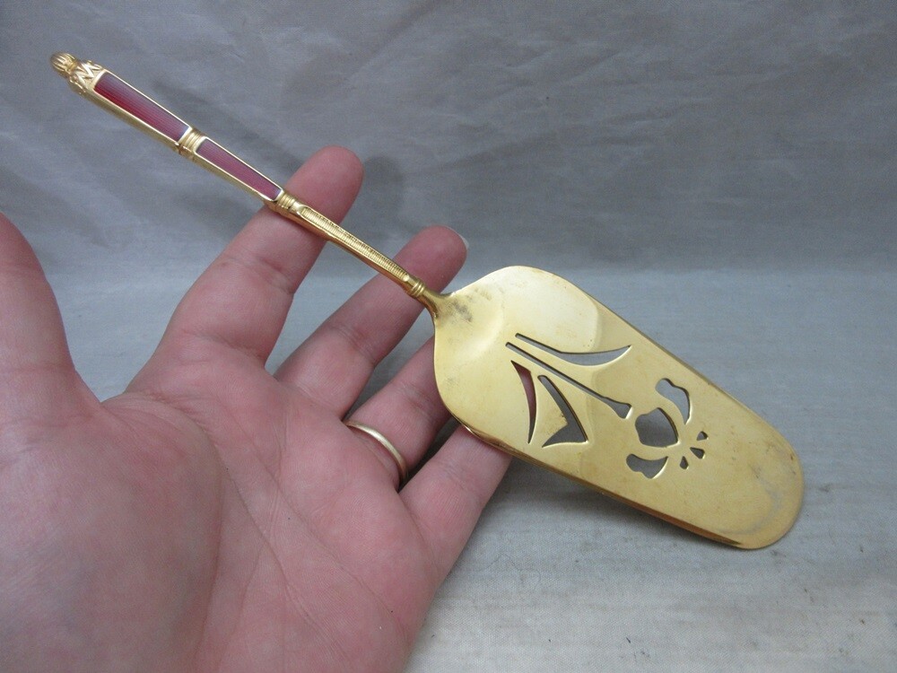 Gold plated cake server with red enamel handle