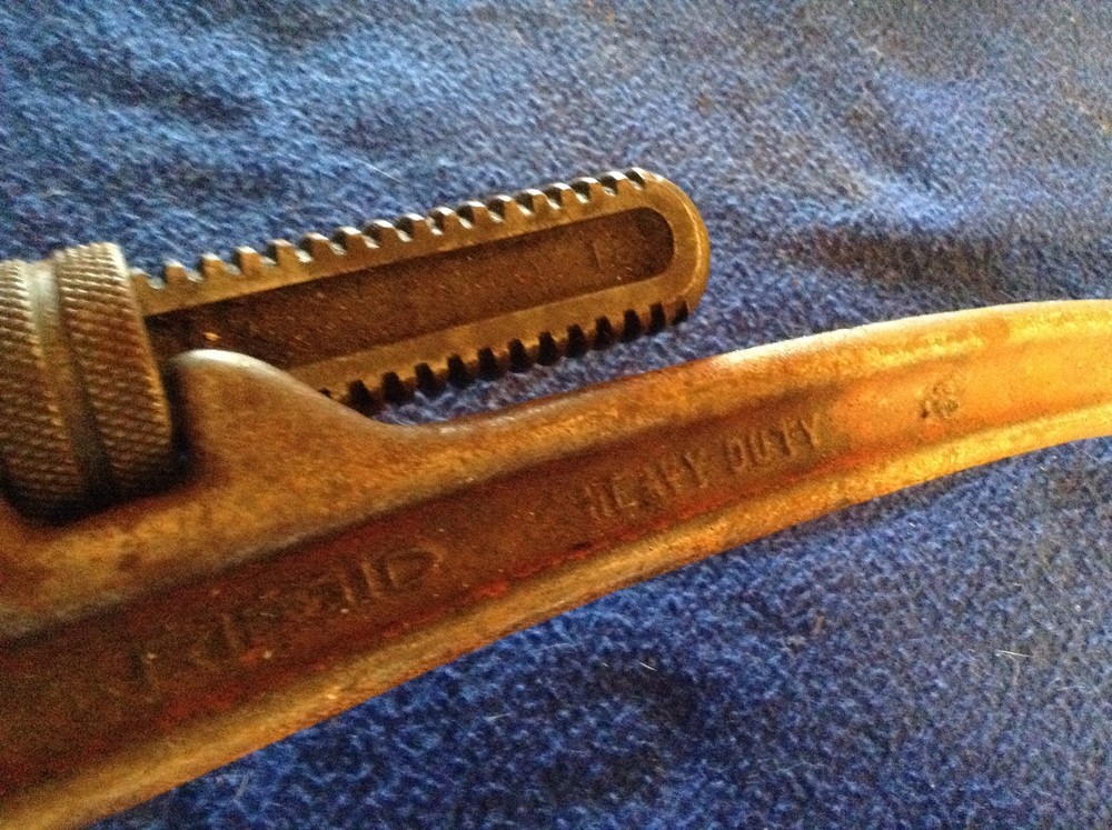 Rigid heavy duty pipe wrench