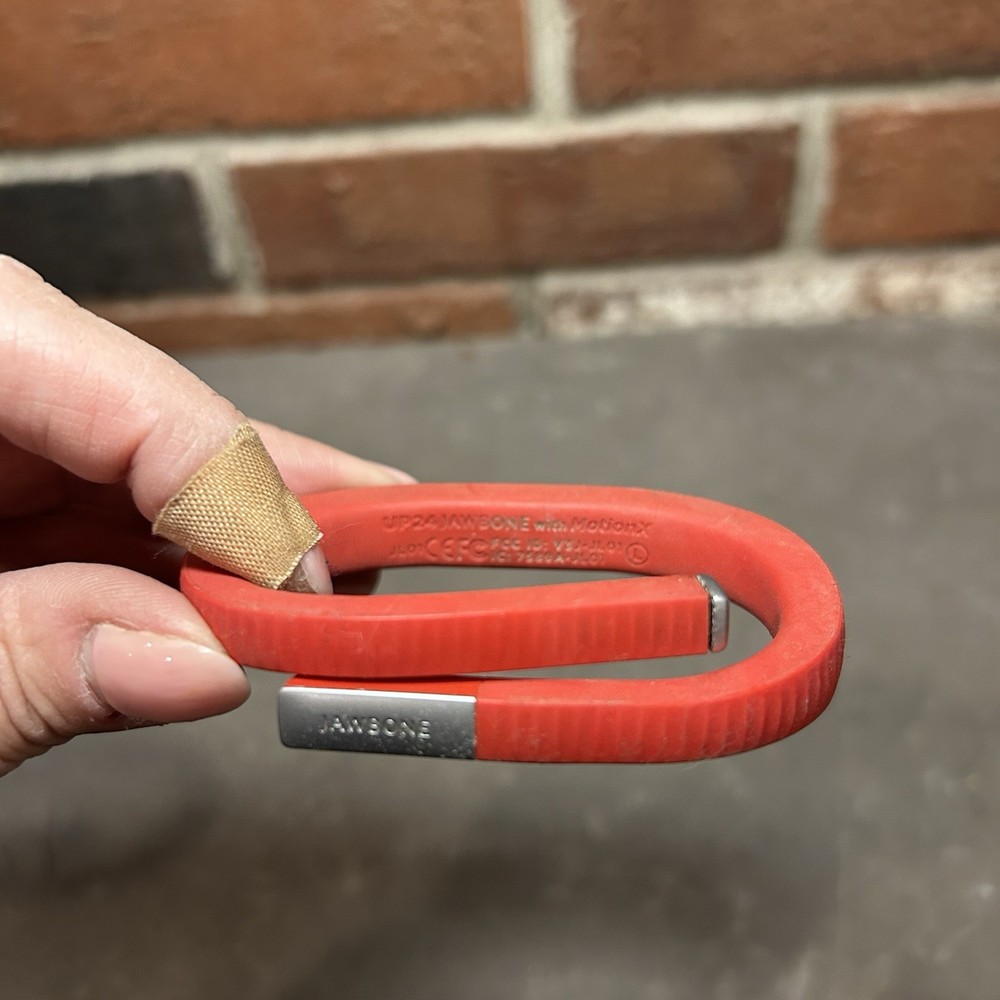 Jawbone UP24 Activity Tracker along with its charging cable Red