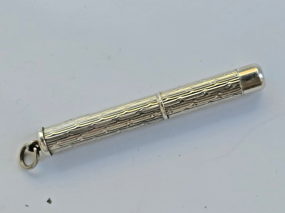 Engine turned silver tooth pick with plastic tool